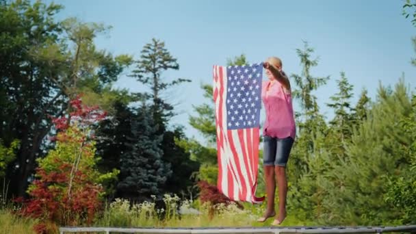 Deportiva mujer con bandera de EE.UU. saltando sobre trampolín — Vídeo de stock