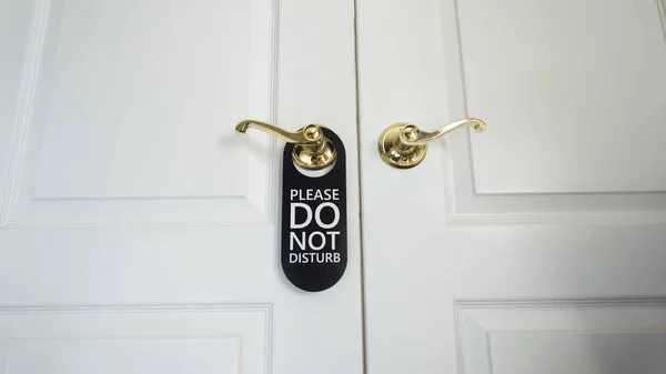 Do not disturb sign hanging on the door of a hotel room — Stock Photo, Image