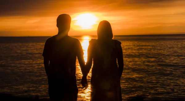Mladý párek-asijský muž a jeho těhotná žena sledují slunce nad mořem — Stock fotografie