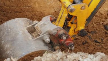 Şantiyede kazı çalışmaları. Ekskavatör kovası zemini kaldırır