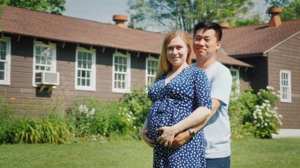 Jonge multi-etnische paar-Aziatische man en zwangere blanke vrouw staan voor hun nieuwe huis — Stockvideo