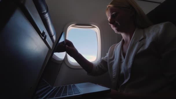 女性は飛行機の中でラップトップを開きます, 出張の概念 — ストック動画