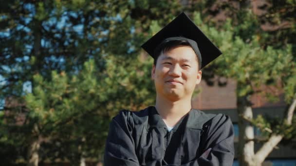 Jovem asiático em roupas de pós-graduação. Conceito de graduação universitária — Vídeo de Stock