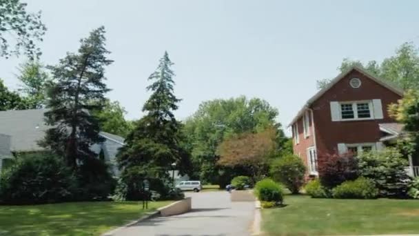 View from a car window to a typical American street, houses and well-groomed territory — Stock Video