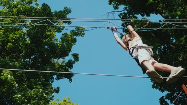 A brave child takes steps on a staggered cable at a height. Overcome fear concept — Stock Video