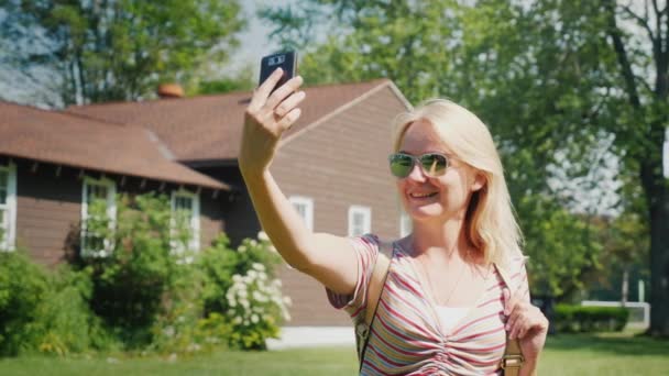 Genç bir kadın ahşap bir evin yanında fotoğraflandı. Nice bungalov tatil — Stok video