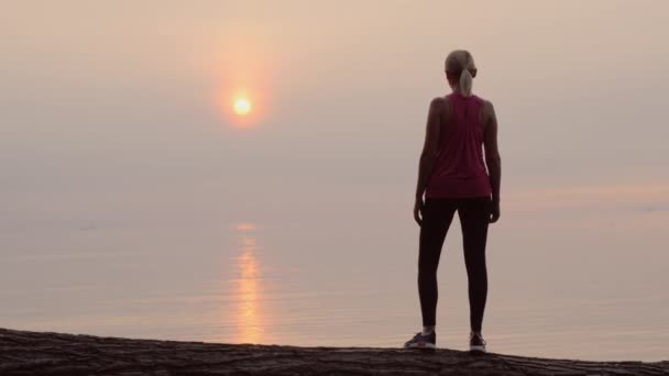 Magabiztos fitness nő nézett hajnalban a tenger felett, a hátsó kilátás