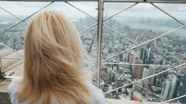 Жінка дивиться через бари на панораму Нью-Йорка. Один у великій концепції міста — стокове відео