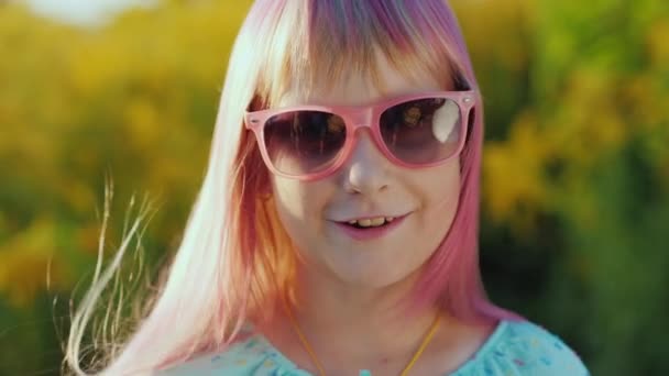 Porträtt av en lycklig flicka med rosa hår i rosa solglasögon — Stockvideo