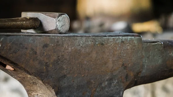 The hammer lies on the anvil, close-up with a blurred background