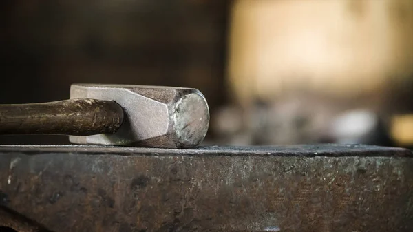 Primer plano de martillo se encuentra en el yunque, primer plano con un fondo borroso — Foto de Stock