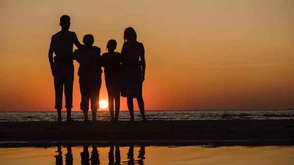 Οικογένεια με τα παιδιά και τη γιαγιά σεπιχειρήσουν μαζί στο ηλιοβασίλεμα πάνω από τη θάλασσα — Φωτογραφία Αρχείου