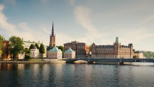 Stadsgezicht van Stockholm, de gebouwen en de brug worden weerspiegeld in het water — Stockvideo