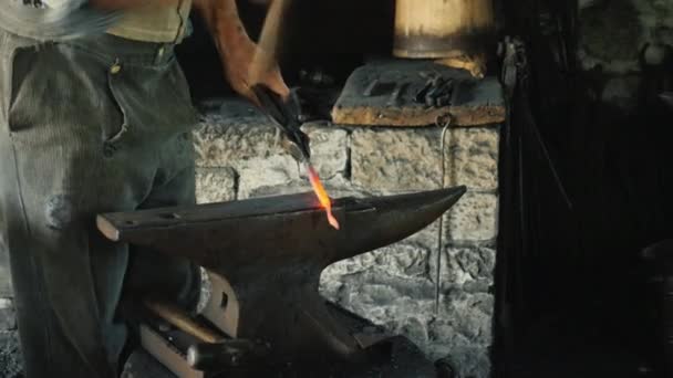 Traditionella hantverk-en smed smedjor ett järnverk, bara en hammare och städet är synliga i ramen — Stockvideo