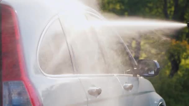 Vista lateral de un coche lavado con una lavadora de alta presión — Vídeos de Stock