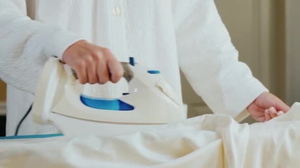 Mujer planchando una camisa blanca — Vídeo de stock