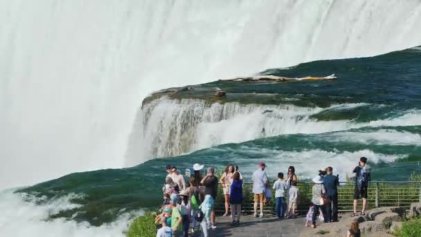 Cataratas del Niágara, NY, EE.UU., julio de 2019: Un grupo de turistas en la plataforma de observación en las Cataratas del Niágara - mire una de las maravillas naturales más increíbles de América — Vídeo de stock