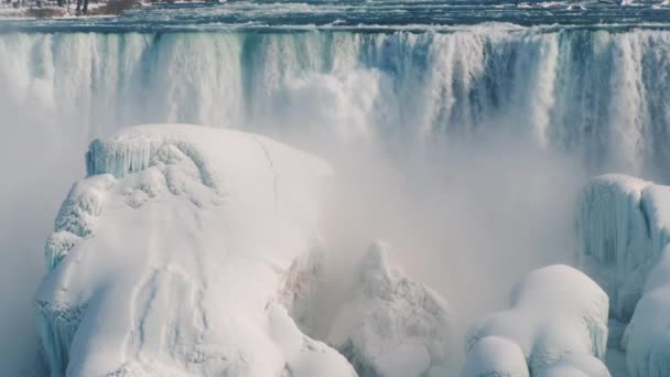 V zimě padá proud vody na ledové útesy-Niagarské vodopády — Stock video