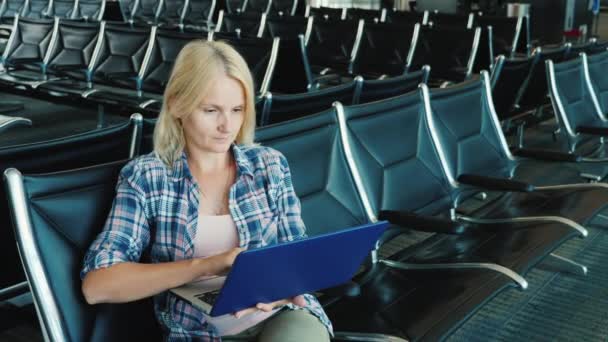El pasajero en el salón del aeropuerto utiliza un ordenador portátil . — Vídeos de Stock