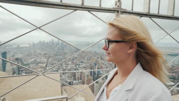 Вид сбоку на женщину, восхищающуюся Нью-Йорком с высокой точки — стоковое видео