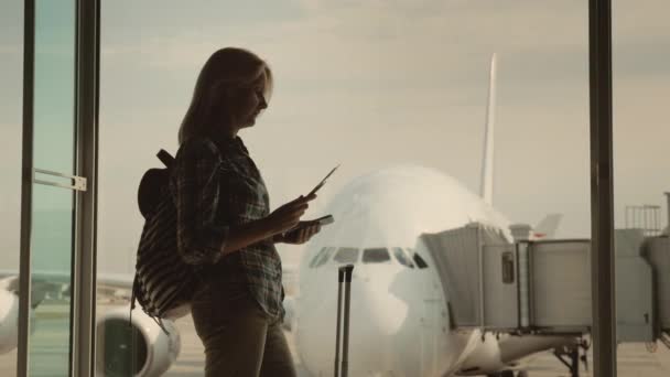 一个年轻的女人在等着登机。持有护照和登机牌。旅程的开始 — 图库视频影像