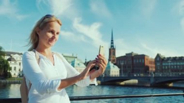 Genç Kafkas kadın Stockholm, İsveç şehrinin güzel bir görünümü fon karşı kendini fotoğraf