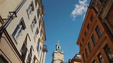 St Nicholas düşük açı geniş atış - Stockholm Storkyrkan çan kulesi. Eski evler ile dar bir sokaktan görünümü