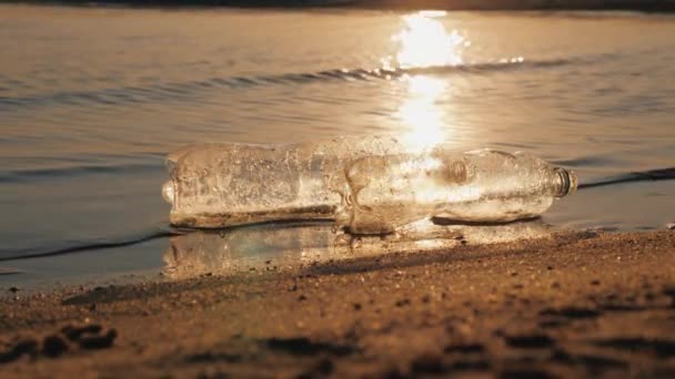Deux bouteilles en plastique flottent dans l'eau près du rivage. Concept de pollution plastique — Video