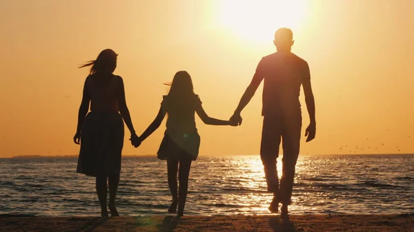 Rodina s dítětem jede k moři při západu slunce — Stock fotografie