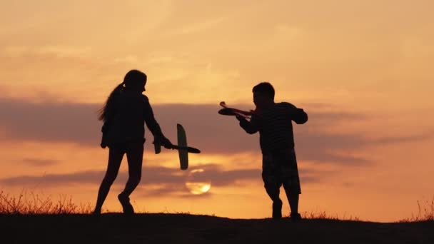 Счастливые дети играют в пилотов, бегают с игрушечными самолетами в руках — стоковое видео