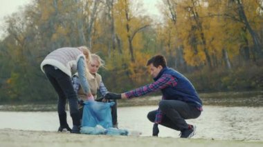 Volunteers clean household waste by the lake