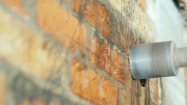 Çelik matkap tuğla duvarda bir delik açar