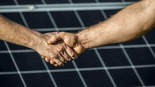 Két üzletember kézfogása a napelemek háttérfelületén — Stock Fotó