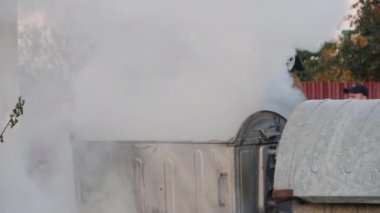 Poltava, Ukrayna, Ekim 2019: İtfaiyeci ayaklanmanın ardından çöp bidonları yakınlarında yangın çıkardı