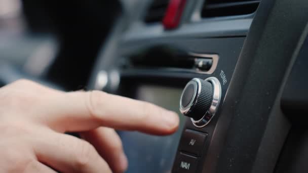 Os dedos de um homem pressionam botões no rádio do carro. Música em movimento — Vídeo de Stock