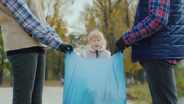 Портрет ребенка-добровольца, собирающего мусор в парке — стоковое видео