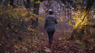 Elinde fener olan bir kadın karanlık bir ormanda yürüyor ve bir şeyler arıyor..