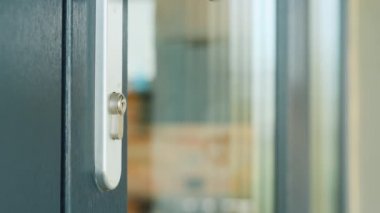 Adam anahtarla ön kapıyı açıyor.