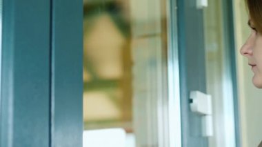 Kadın kapıyı çalar, içeri bakar.