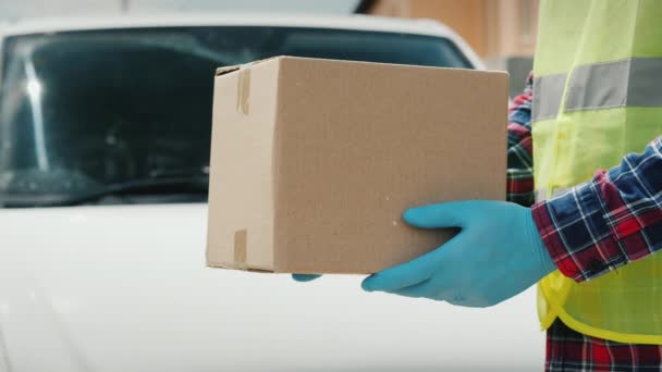 De koerier overhandigt het pakket van de ontvanger in de buurt van de witte bestelwagen — Stockvideo