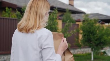 Arkadan bakınca: Genç bir kadın evine poşet dolusu yiyecek taşıyor