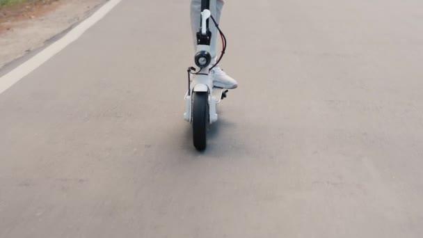 A roda de uma scooter elétrica que anda na estrada — Vídeo de Stock