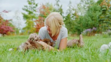 Birçok köpek yavrusu kadınların etrafında oynar.