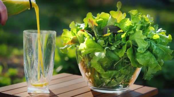 In einem Glas gegossen einen grünen Cocktail aus Salat, neben einer Schüssel mit Gemüse — Stockvideo