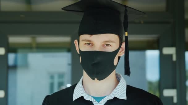 Portret van een man met een pet en badjas en een beschermend masker op zijn gezicht — Stockvideo