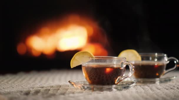 Duas xícaras de wow quente em uma mesa junto à lareira, o vapor vem de uma bebida quente — Vídeo de Stock