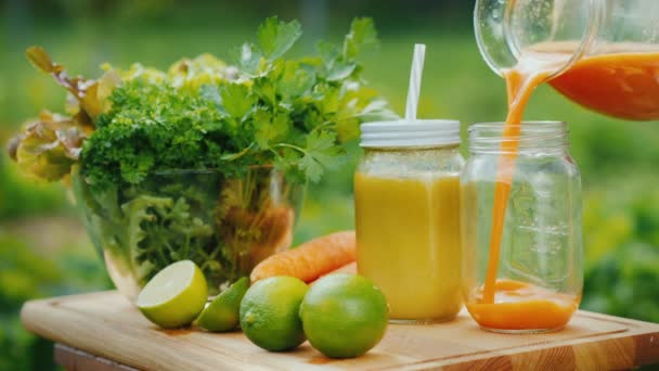 Pour a healthy juice, next to a set of fruits and greens. — Stock Video