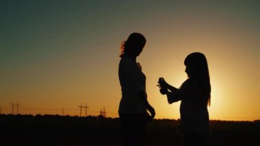 Kız, böceklere karşı sprey sıkarak annesinin üzerine serpiştiriyor.