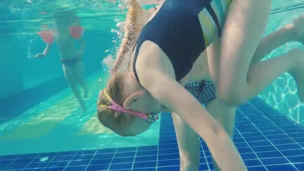 A lány lemerül a medencébe. Tanulj meg merülni és érezd jól magad. — Stock videók