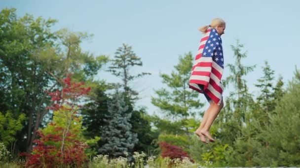 Žena s americkou vlajkou skákání na trampolíně na ramenou — Stock video
